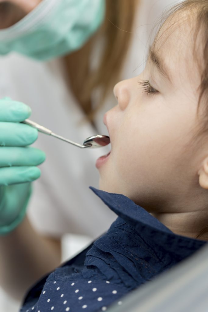 Dentist examining young child's teeth