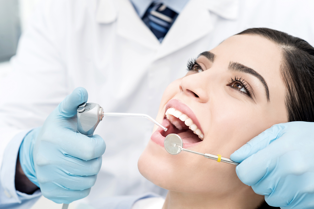 Dentist prepares to clean womans teeth