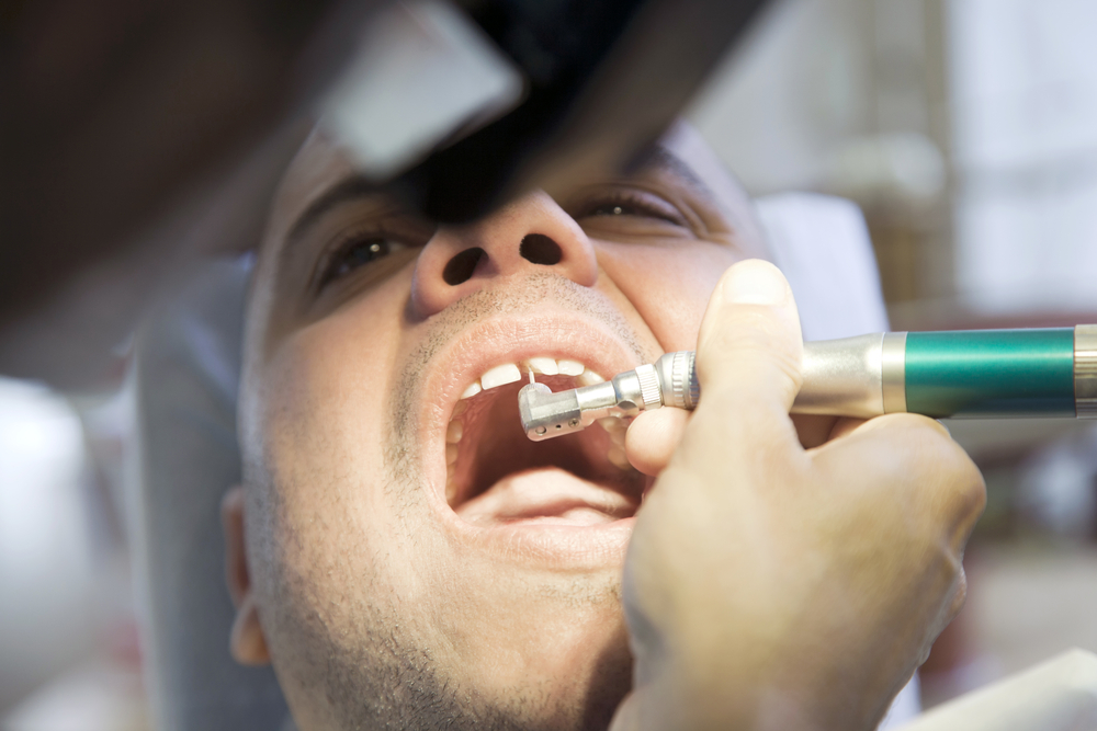 Man getting his teeth cleaned by dentist