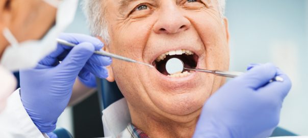 Dentist examines an old mans teeth