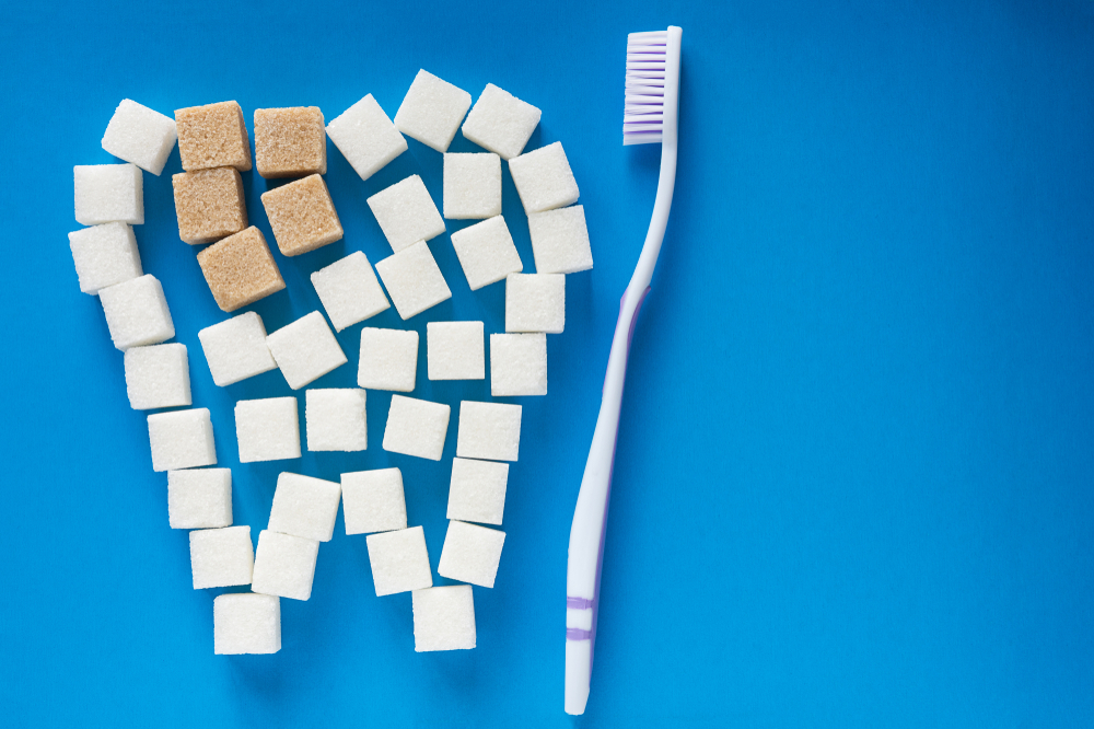 sugar cubes in the shape of a tooth next to a toothbrush