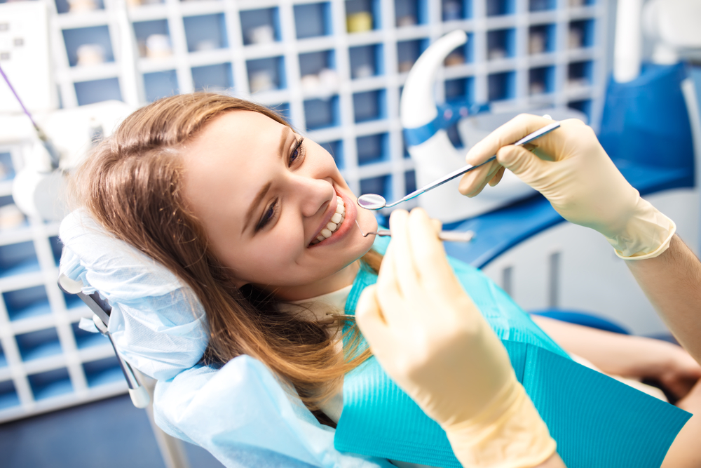 Woman smiling as dentist prepares to check her teeth