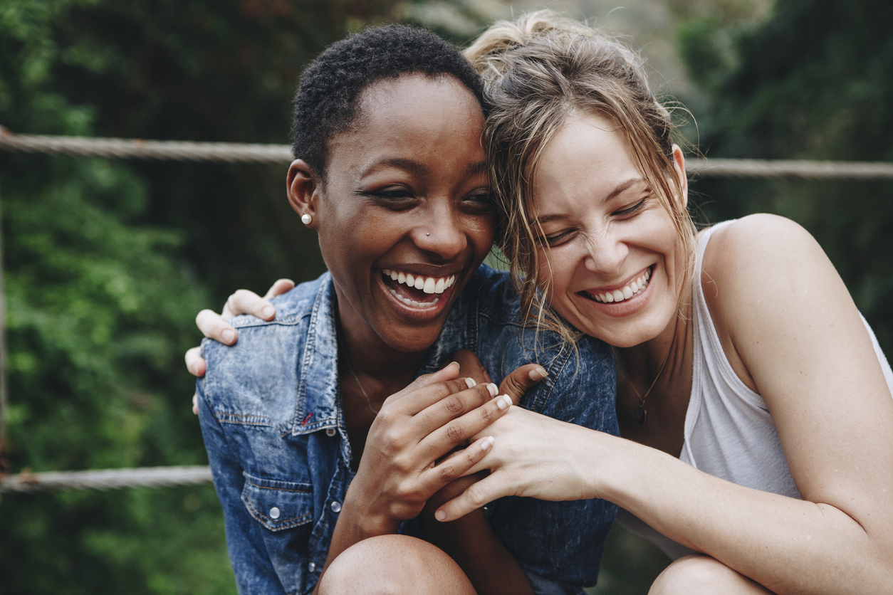 Happy friends holding each other and smiling