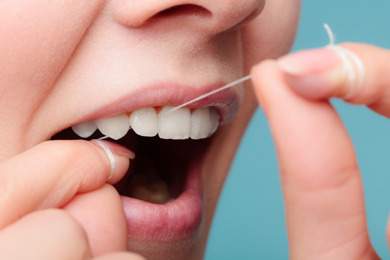 Oral hygiene and health care. Smiling women use dental floss white healthy teeth.
