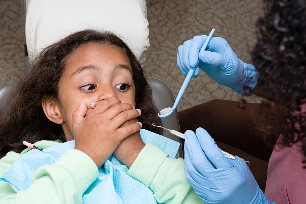 Girl covering mouth at the dentist