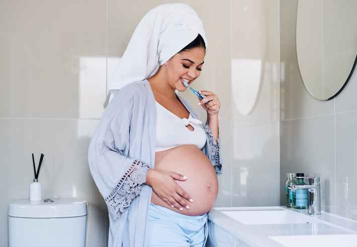 Shot of a pregnant woman brushing her teeth in the bathroom at home