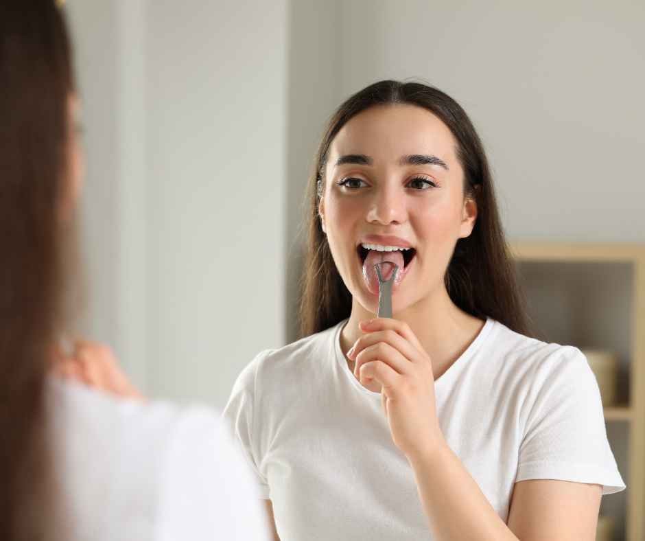 A woman using a tongue scraper