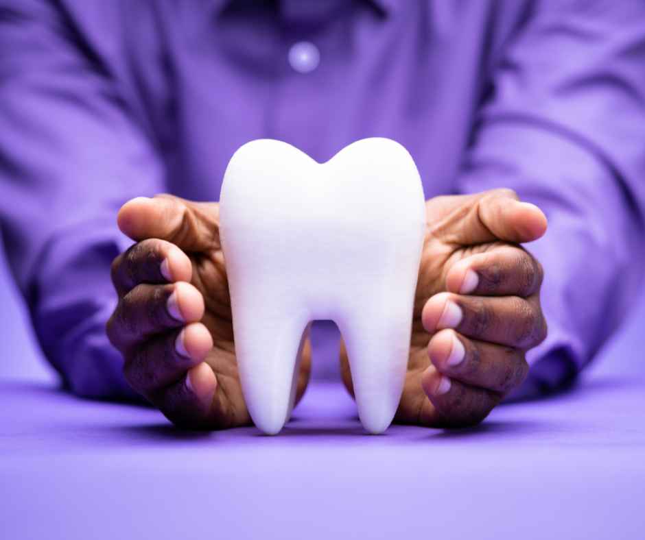 Hands surrounding a large tooth display